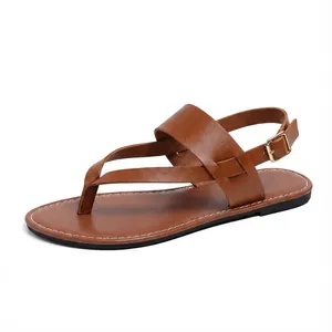 Side view detail of brown flat leather thong sandals with adjustable buckle strap