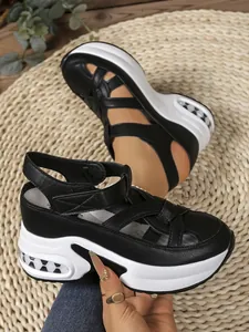 Close-up detail of stylish black and white platform sandals featuring comfy velcro straps.