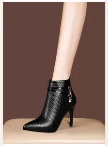Close-up of black pointed-toe stiletto ankle boots with textured leather and rhinestones.