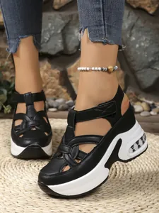 Detail view of black platform sandals with woven cut-out design and adjustable Velcro straps