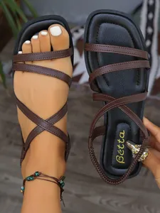 Vue détaillée des sandales romaines plates à brides croisées marron pour femmes avec élastique