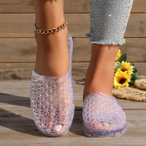 Close-up of women's crystal clear hollowed-out mules with breathable knit pattern.