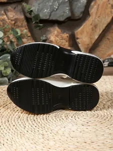 Close-up detail of the anti-slip black patterned outsole for women's wedge sandals