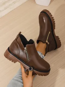 Detailed side view of brown women's Martin boots with thick rubber lug sole