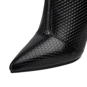 Detailed close-up view of black pointed-toe fashion boot with geometric textured pattern
