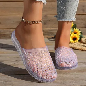 Detailed macro view of purple glitter hollow-out jelly slippers on a rustic wooden deck