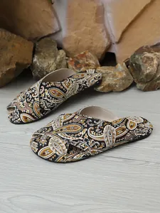 Close-up of women's flat sandals with intricate paisley print and cross-strap design