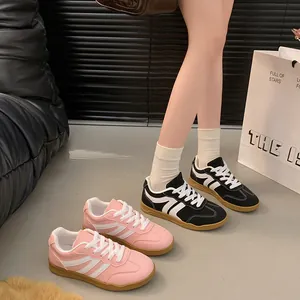 Baskets rétro pour femmes en rose et noir présentées avec style sur le sol
