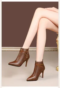 Close-up of brown stiletto ankle boots featuring diamond texture and dangling rhinestone charms