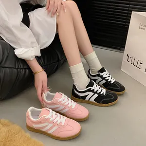 Gros plan de baskets rétro bicolores noir et rose avec semelles en gomme pour femmes