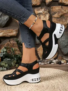 Outdoor lifestyle shot of black and white chunky platform sandals with Velcro straps