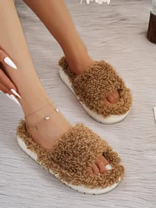 Detailed view of brown fuzzy platform slippers featuring plush faux fur on a grey rug