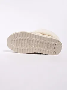 Close-up detail of the anti-slip textured sole on beige plush-lined warm snow boots