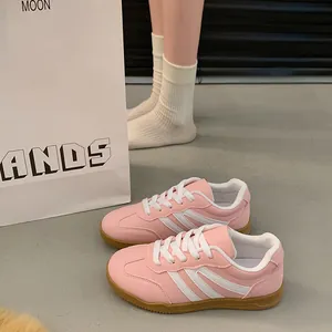 Vue détaillée des baskets rétro roses German Army Trainer pour femmes en scène de style.