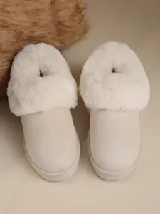 Detail view of beige women's snow boots with fluffy white fur collar for winter warmth.