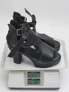 Professional weighing of black platform Roman sandals on an electronic digital scale