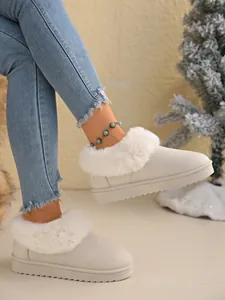 Detailed view of women's warm snow boots with white faux fur trim and suede finish