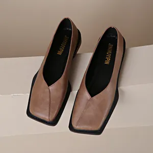 Primer plano de bailarinas vintage marrones con punta cuadrada y escote en V en cuero suave