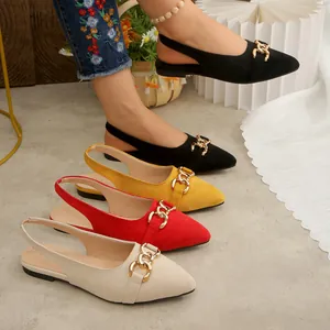Detailed view of pointed-toe flat suede slingback shoes with decorative gold chain accents