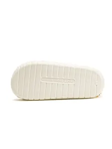Detail view of the white anti-slip outsole of the fuzzy slippers