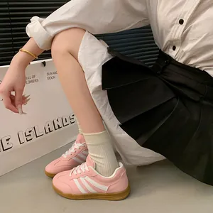 Gros plan des baskets roses pour femmes style rétro avec bandes blanches et semelle en gomme