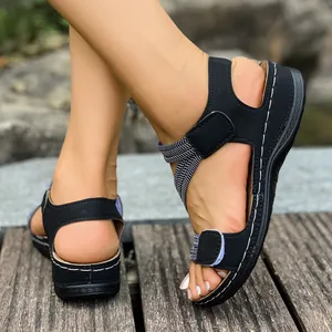 Detailed view of women's black sporty sandals with adjustable velcro straps on feet