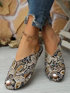 Close-up of women's ethnic flat slippers featuring vintage paisley print and peep-toe design.