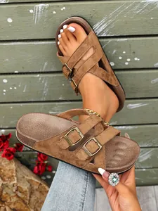 Detailansicht der braunen Plateau-Sandalen aus Wildleder mit doppelten Metallschnallen