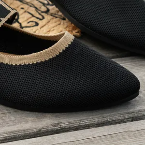 Detailed close-up showing the breathable flyknit texture of black pointed-toe flat shoes