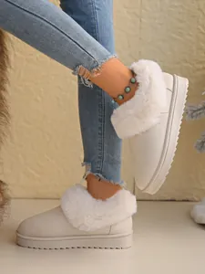 Close-up of model wearing warm white plush-trimmed snow boots with stylish turquoise anklet
