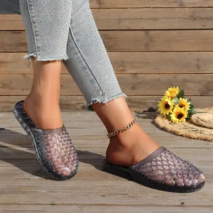 Close-up of breathable hollowed-out crystal slippers worn on a rustic wooden floor