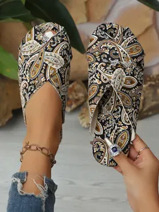 Detailed view of ethnic paisley print on flat crossover strap sandals for women.