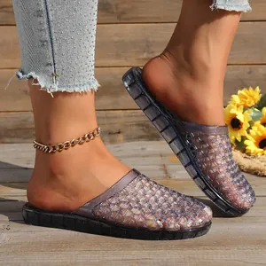 Detailed view of women's hollow mesh breathable jelly slippers shown on a rustic wooden porch.