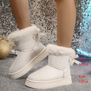 Detailed view of white fur-lined snow boots with decorative bow and thick platform sole.