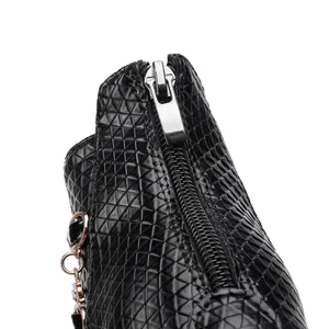 Detail view of black geometric textured ankle boot with silver zipper pull