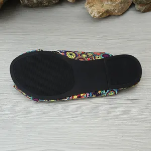 Detailed bottom view of ethnic print flat sandal with black anti-slip rubber sole