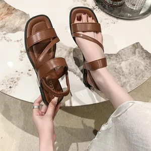 Detailansicht brauner PU-Leder-Sandalen mit Kreuzriemen und elastischem Fersenriemen.