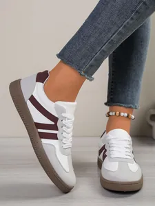 Close-up of women's color-blocked German Army Trainer sneakers worn with jeans.