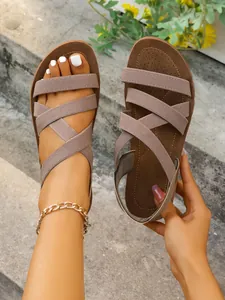Stylish women's flat Roman sandals featuring elastic criss-cross straps for summer wear