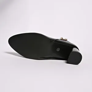 Detailed view of the anti-slip sole and block heel of a black rhinestone ankle boot