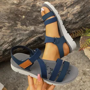 Detailed shot of blue criss-cross strap flat sandals featuring a white platform sole.