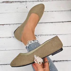 Dettaglio macro di ballerine scamosciate kaki con punta elegante e suola nera resistente.