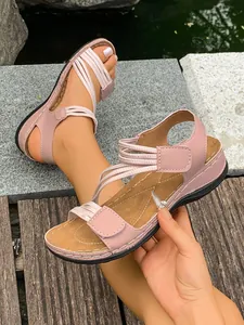 Close-up of pink sporty flat sandals featuring elastic straps and secure Velcro closure