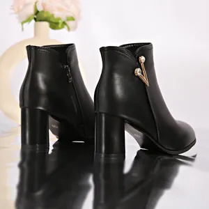 Rear-side view of black chunky heel ankle boots featuring elegant rhinestone V-detail