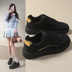 Women's black chunky platform sneakers with metallic gold accents and round toe design