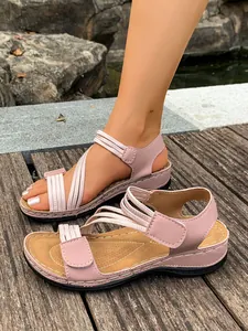Close-up of pink women's wedge sandals with elastic straps and Velcro