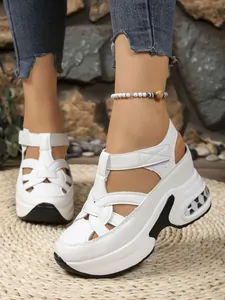 Detail of white platform sandals featuring woven straps and adjustable velcro closure