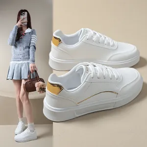 Detailed side view of women's white platform sneakers with elegant gold heel accents