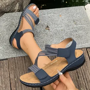 Close-up detail of women's sporty flat sandals with striped elastic straps and velcro closure