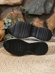 Detail of non-slip black platform sole on stylish white women's closed-toe summer sandals